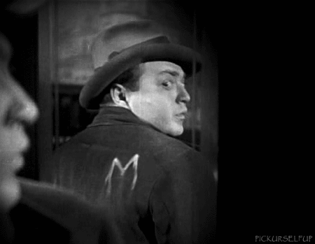Peter Lorre looking at the letter M on his jacket